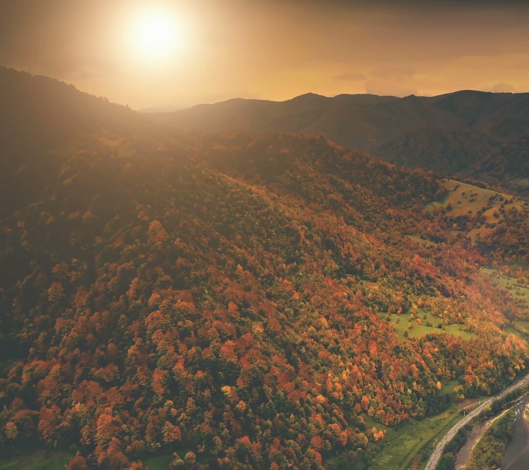 Aerial view of an autumn canyon village nestled along a winding river, symbolizing the connection between landownership and natural resources.